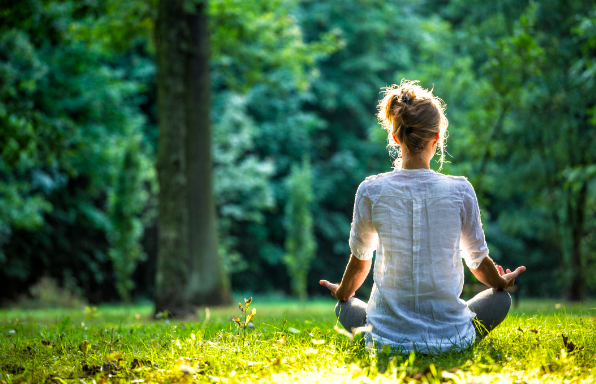 Person practicing mindfulness meditation on a sunny day