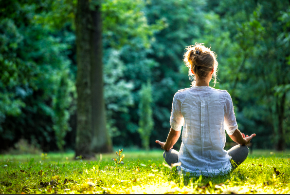 Person practicing mindfulness meditation on a sunny day