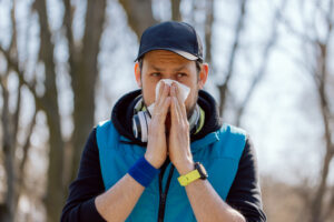 An athlete stops running practice due to a runny nose, blows his nose in a handkerchief. Illness interferes with exercise