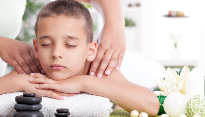 young boy relaxing in spa. stone massage.