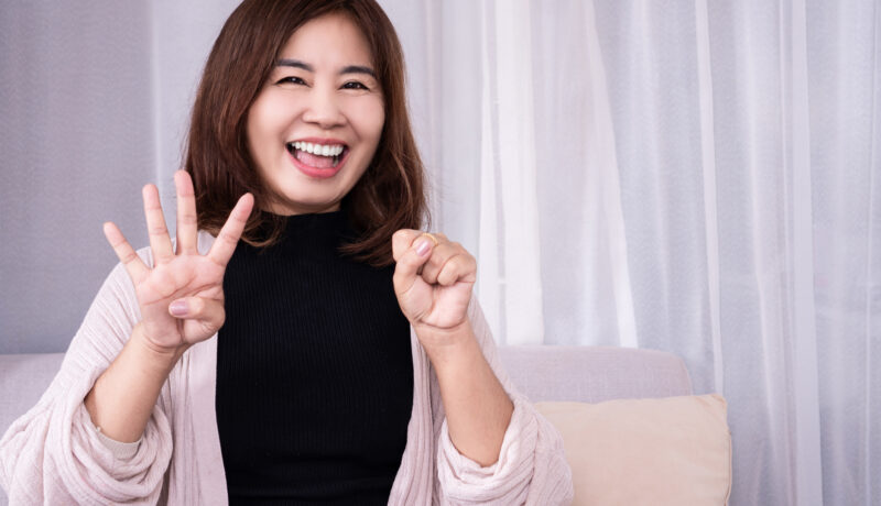 happy woman smiling with hand showing her age 40 , menopause happy concept